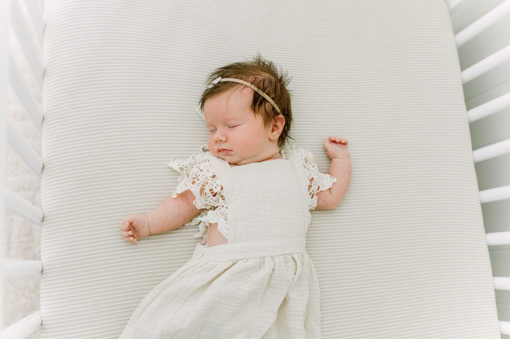 Milwaukee newborn photography with baby laying in crib
