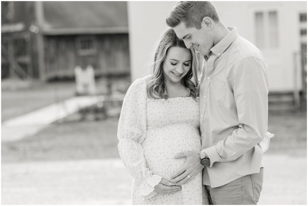 Mom and dad smiling down at baby during Milwaukee maternity session
