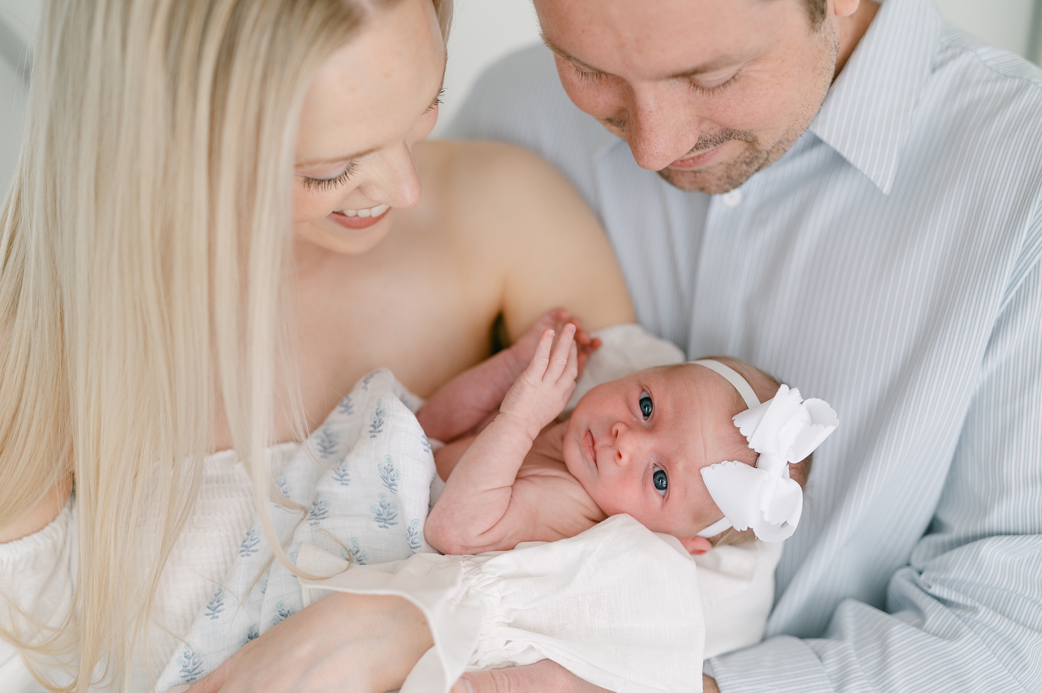 Mom and dad smile at their baby during a Whitefish Bay newborn session