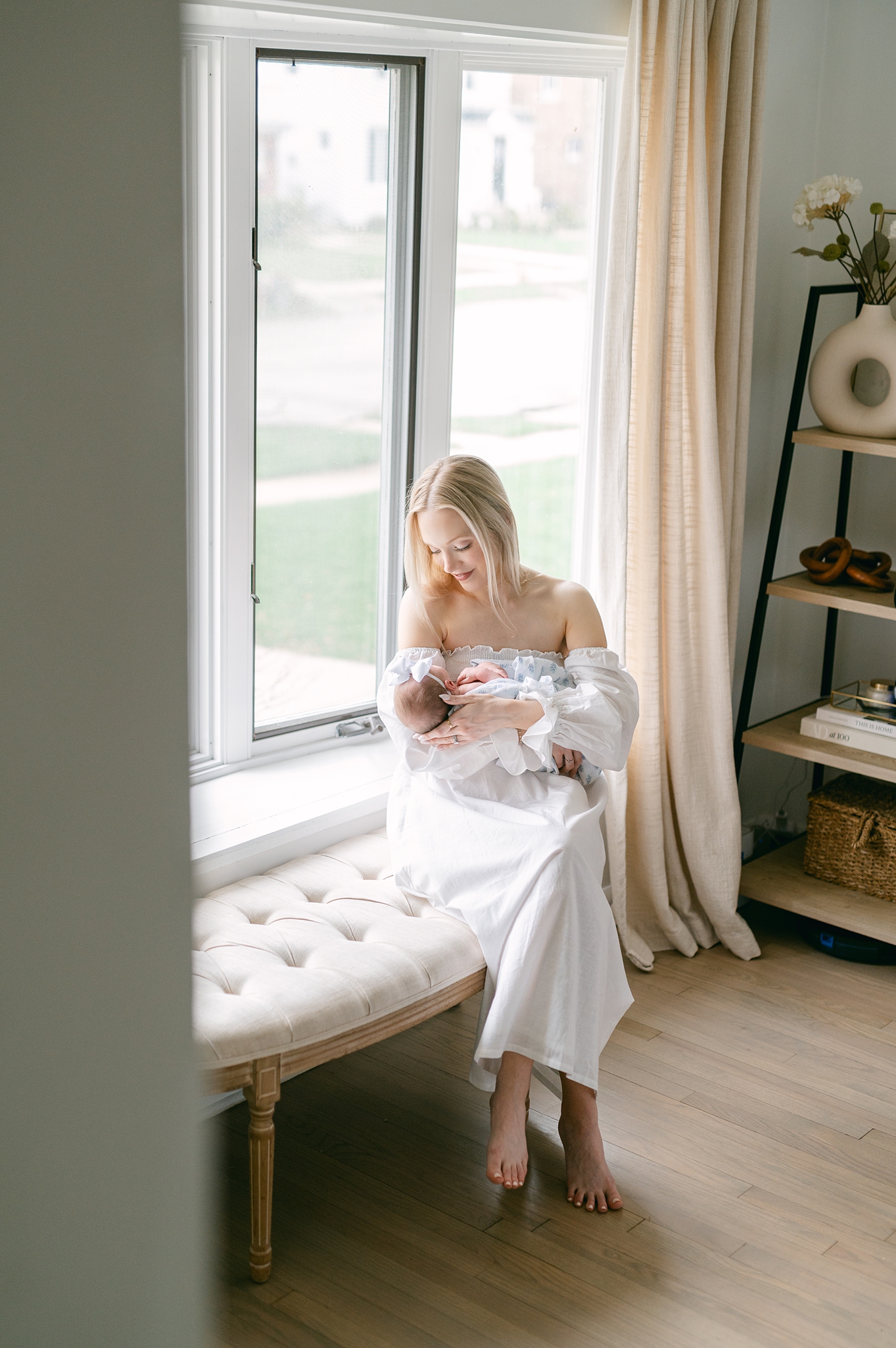 Mom holds her baby next to a window during a newborn session with Abby Park Photography in Milwaukee
