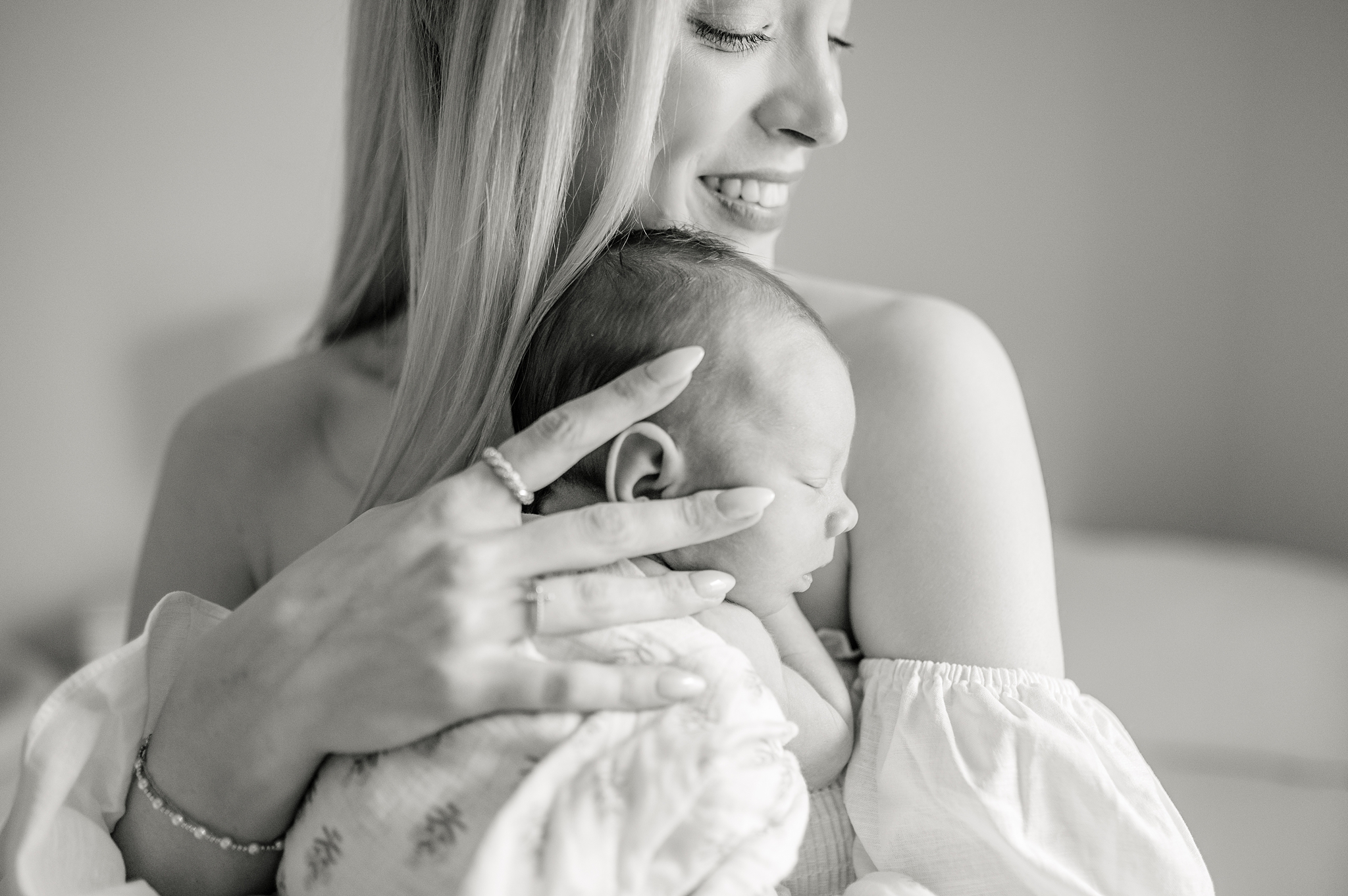 Black and white image of baby asleep on her mom's chest during a Whitefish Bay Lifestyle newborn session