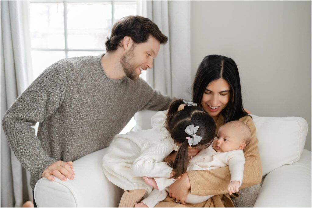 Family of 4 looking at their baby during Abby Park Photography's newborn session 